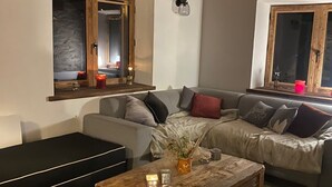 Ein gemütliches Wohnzimmer mit einer Couch, einem Couchtisch und einem Fenster mit Aussicht.