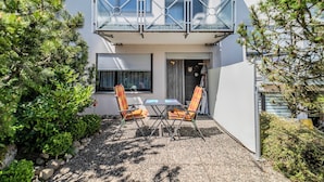A modern two-story house with a balcony, a small patio with two chairs and a table, and a well-maintained garden. - FE-WO Paradiso, 78141 Schönwald in the Black Forest With swimming pool and sauna 1000m.a.s.l. (Schönwald im Schwarzwald)