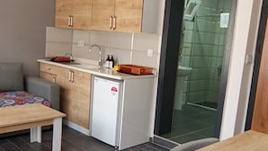 Ein kompakter Wohnbereich mit Küchenzeile, Essbereich und einer kleinen Sitzecke.