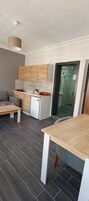 Un espacio habitable compacto con kitchenette, comedor y una pequeña zona de estar.