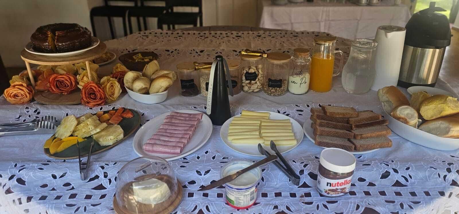 A breakfast table with various food items, including pastries, bread, and condiments.
