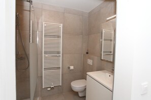 Un bagno con doccia, WC e lavabo.