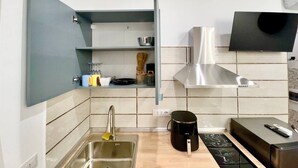 Een moderne keuken met een ingebouwde oven, een RVS afzuigkap en een spoelbak met een kraan.