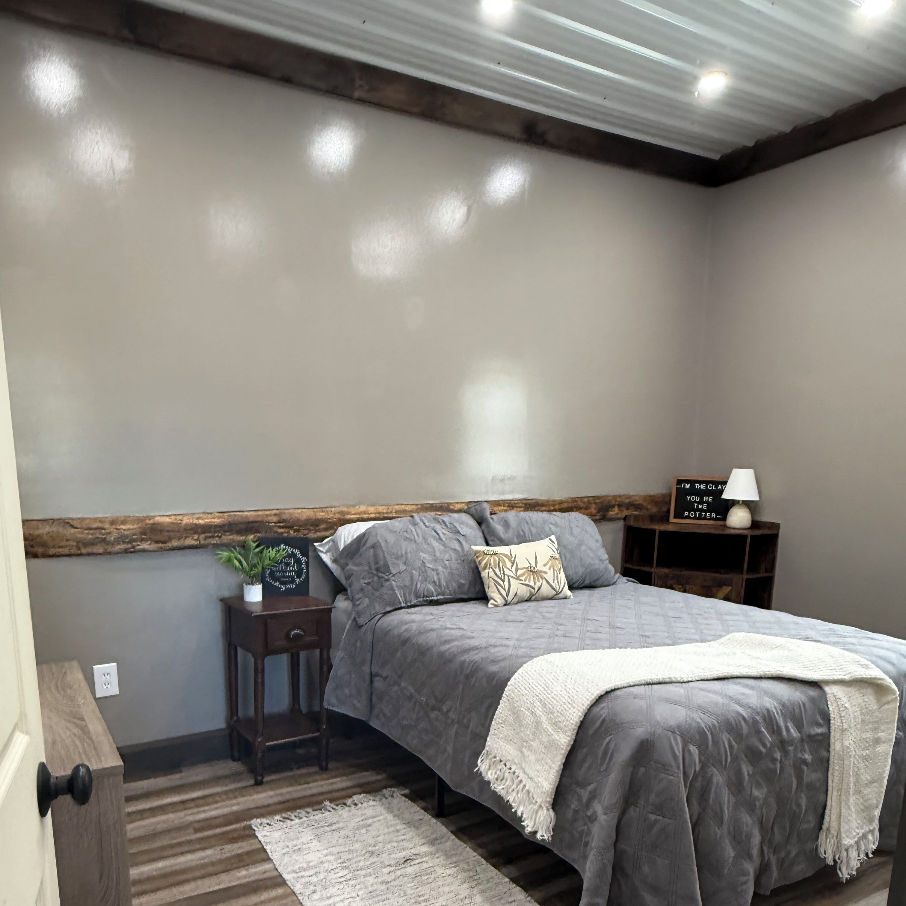 Ein Schlafzimmer mit Bett, Nachttischen, einer Lampe und einem Wandregal.