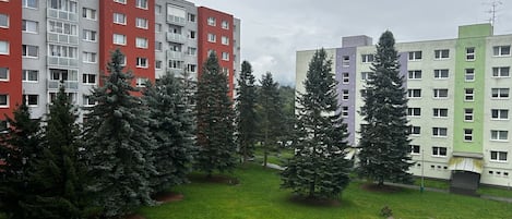 A residential building complex with multiple apartment buildings, green lawns, and trees.