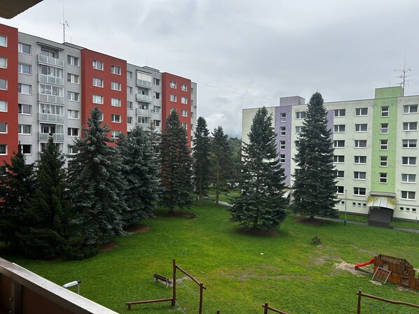 Un ensemble immobilier résidentiel comprenant plusieurs immeubles d’appartements, des pelouses verdoyantes et des arbres.