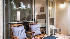 Een kamer met een bed, een raam en twee houten stoelen met kussens.