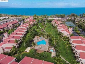 Ein Resort mit mehreren Gebäuden, einem zentralen Pool und Blick auf den Ozean.