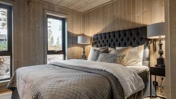 A bedroom with a large bed, wooden walls, and a window.