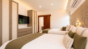 Habitación de hotel con dos camas, un televisor y un armario.