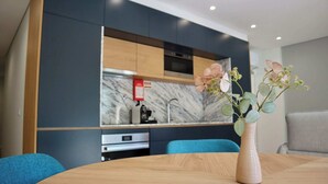 Una cucina moderna con zoccolo in marmo, mobili in legno e un vaso con fiori su un tavolo.