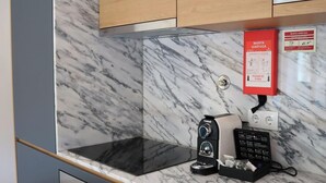 Una cucina moderna con mobili scuri, una schiena di marmo e un forno integrato.
