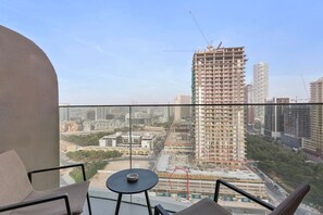 A balcony with a view of a cityscape, including a tall building under construction. - Stylish Comfort Studio in Westwood Grande (Jumeirah Village Circle (JVC))