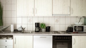 A modern kitchen with white cabinets, a stainless steel sink, a coffee maker, a microwave, and a toaster. - Hechingen: AlbGlück 1 Apartment | 2 bedrooms | sleeps 1–5 | 5 km Castle (Hechingen)