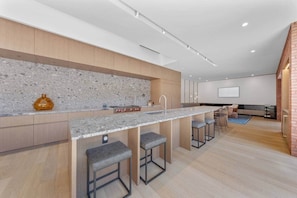 Una cocina moderna con encimera de granito, taburetes de bar y salpicadero.