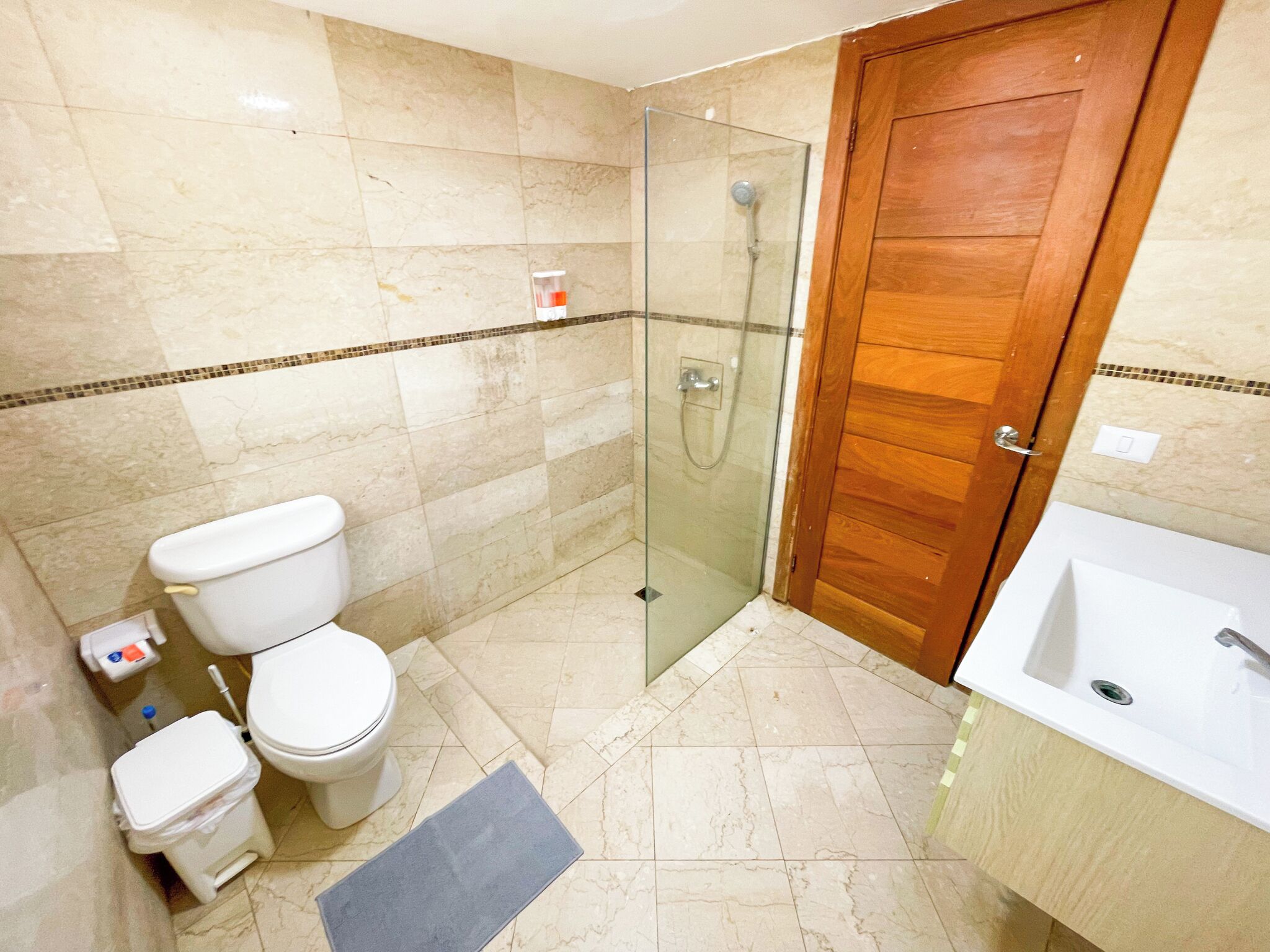 Een badkamer met een toilet, een douche en een wastafel.