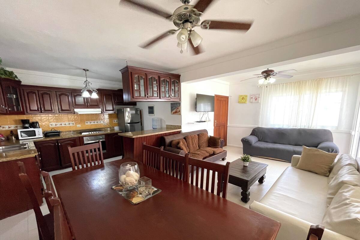 A modern living space with a dining area, kitchen, and seating area.