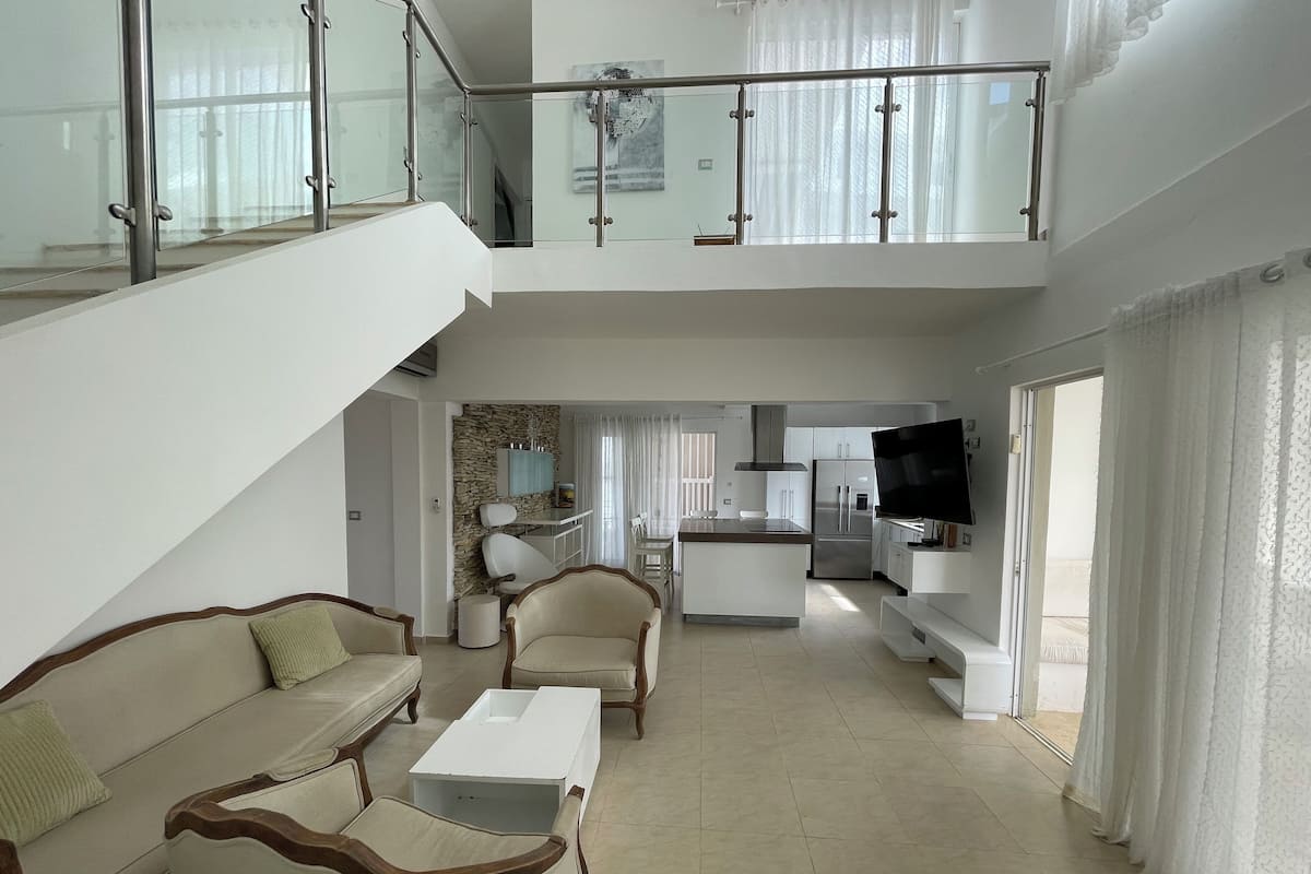 Penthouse de lujo, vista a la alberca, junto a la alberca | Área de sala de estar | Televisión de pantalla plana de 32 pulgadas con canales por cable