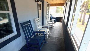 A covered outdoor seating area with benches and a wooden ceiling. - Zora's Sojourn (St. Augustine)