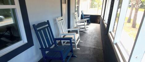 Un espacio de estar al aire libre cubierto, con bancos y techo de madera.