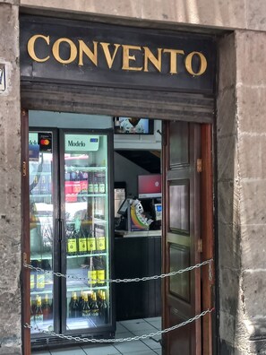 Ein Schaufenster mit einem Schild, das 'CONVENTO' zeigt, und einer Kühlvitrine mit verschiedenen Produkten.