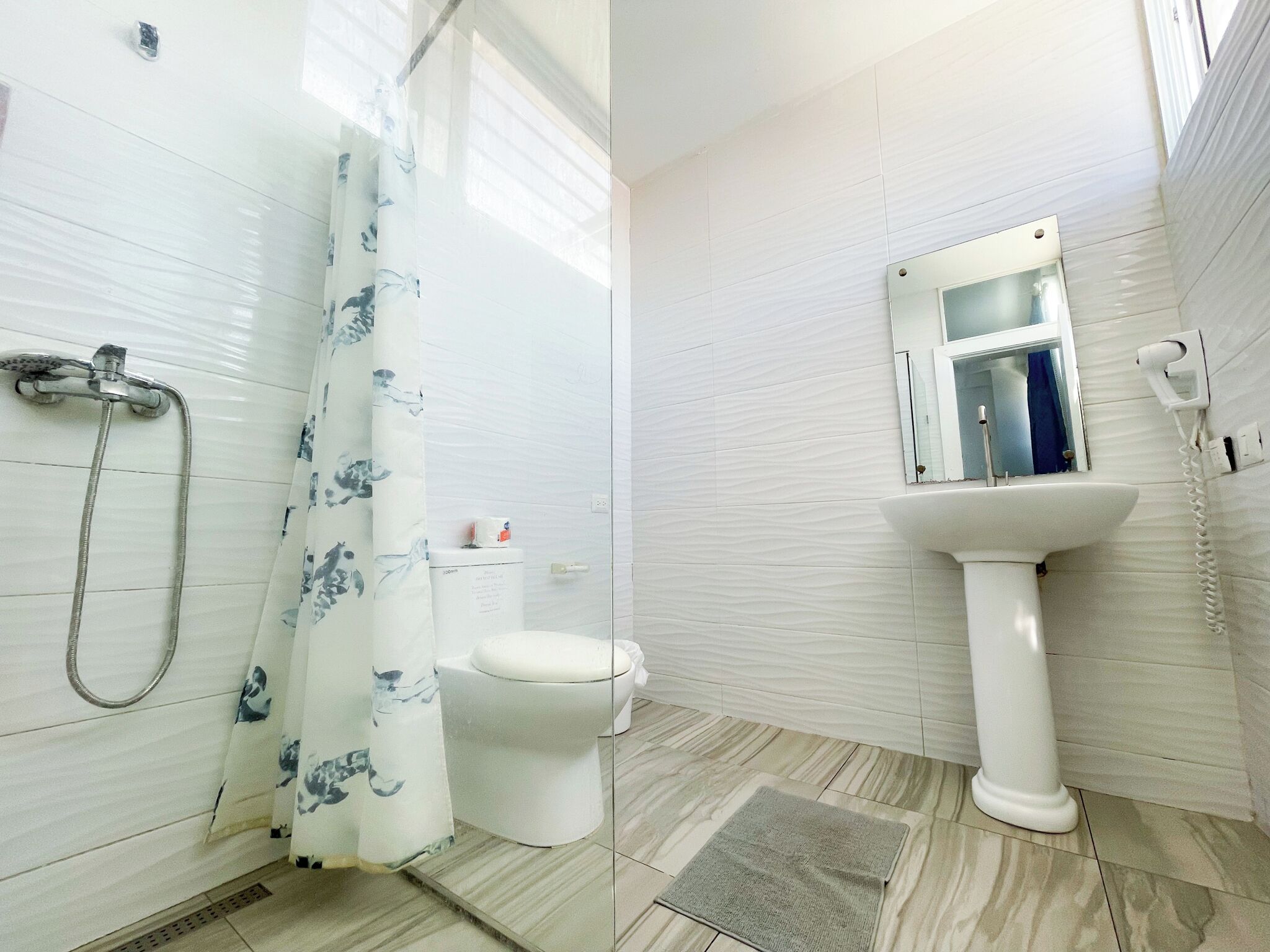 A bathroom with a shower, toilet, and sink.