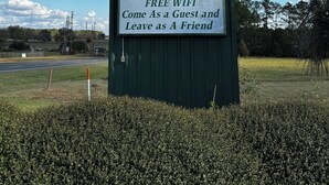 A Western Motel sign with amenities including satellite HBO TV, free WiFi, and a slogan "Come As a Guest and Leave as A Friend". - Western Motel (Dawson)