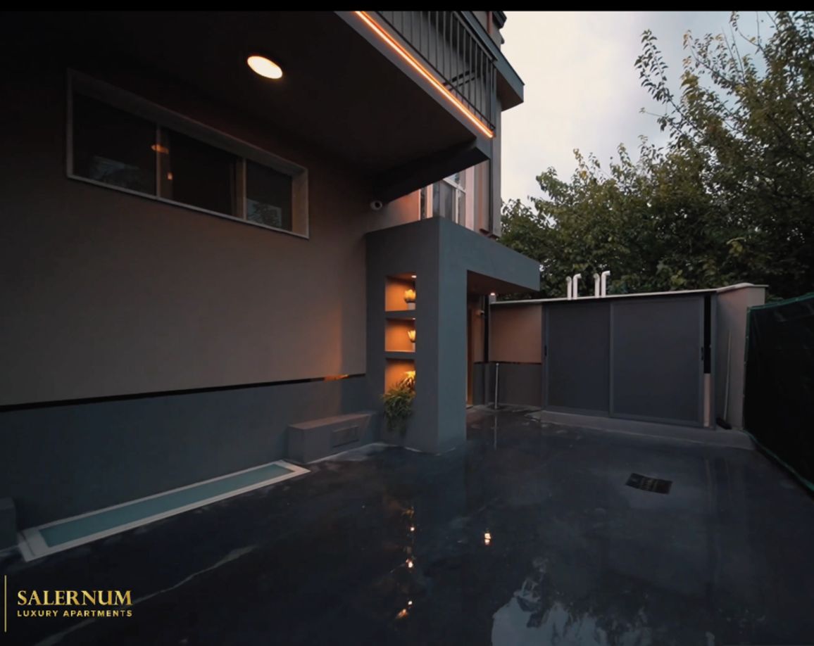 Un edificio moderno con techo plano, ventanas amplias y suelo reflectante.