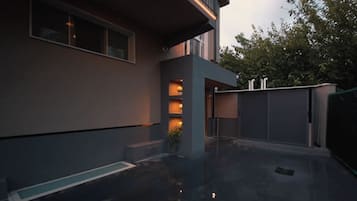 Un edificio moderno con techo plano, ventanas amplias y suelo reflectante.