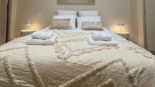 A neatly made bed with a quilt, pillows, and two bedside lamps. - Casa Koenig - T2 spacieux & Terrasse en hyper-centre (Brive-la-Gaillarde)