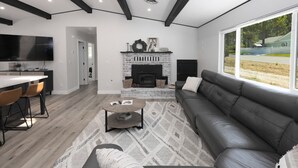 Ein modernes Wohnzimmer mit Kamin, einer Couch, einem Couchtisch und einem Fernseher.