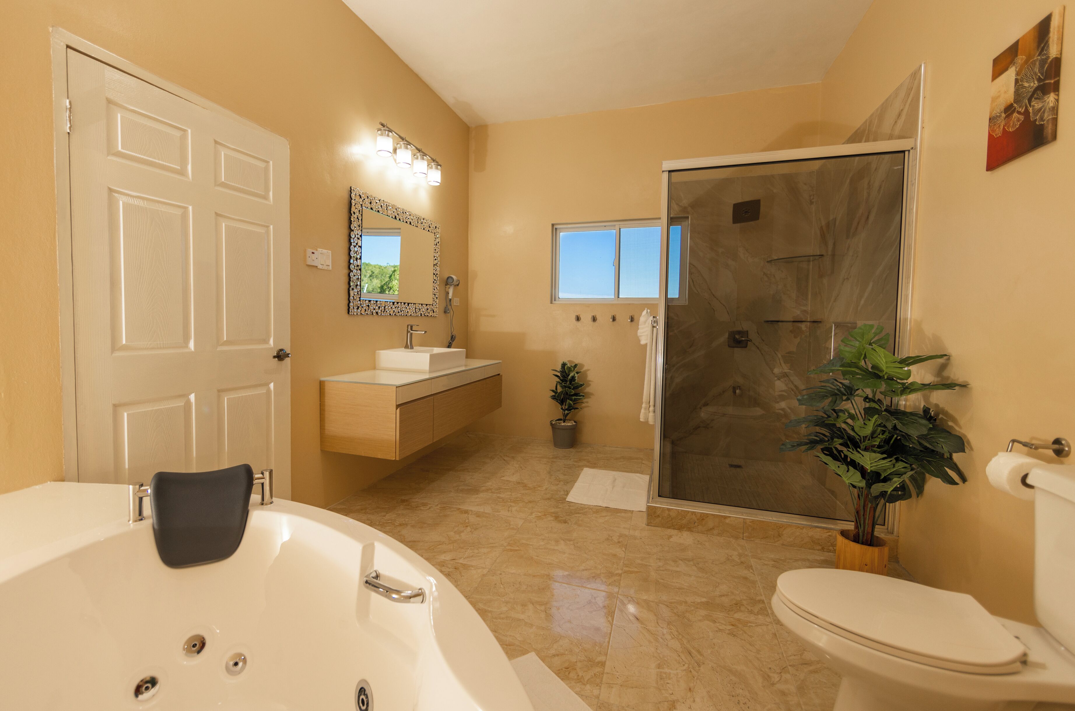 Une salle de bain équipée d’une baignoire, de toilettes, d’un lavabo et d’une douche.