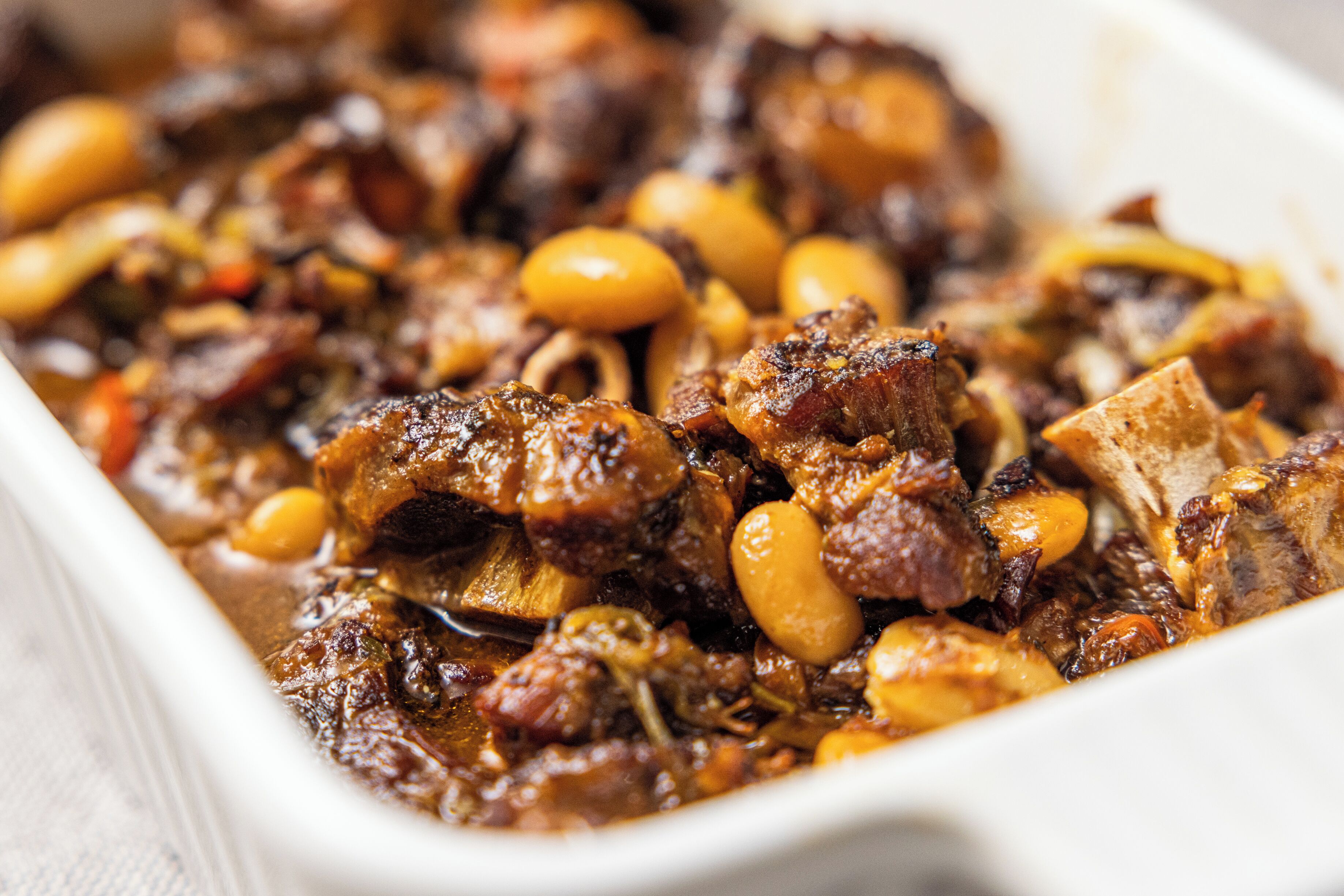 A close-up of a dish with meat and beans.