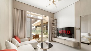 Uma sala de estar moderna com um sofá, mesa de centro e televisão de tela plana.