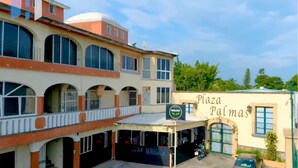 Un edificio a più piani con un cartello che riporta la scritta "Plaza Palmas".