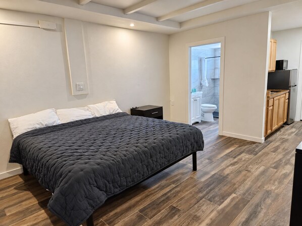 Une chambre à coucher avec un lit, une table de chevet et un plancher en bois.