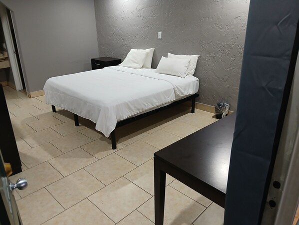 Une chambre à coucher avec un lit, une table de chevet et une table.