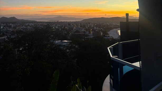 A balcony with a view of a cityscape during sunset. - Beautiful penthouse with a view. (Florianópolis)