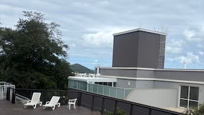 A rooftop pool area with a swimming pool, lounge chairs, and a view of a building in the background. - Beautiful penthouse with a view. (Florianópolis)