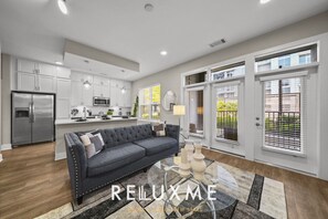 A modern kitchen with white cabinets, stainless steel appliances, and pendant lighting. - Reluxme Luxury 2BR | Walk to Stadiums & Convention Center (Charlotte)