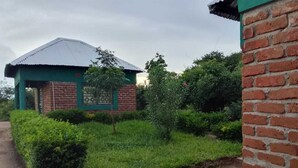 Um pequeno edifício de tijolos com telhado verde e parede de tijolos.