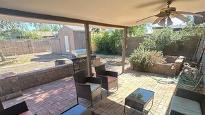 An outdoor patio area with a ceiling fan, wicker furniture, and a barbecue grill. - House in Cozy Old Town Scottsdale with AC, Pool Table, Central Location (Scottsdale)