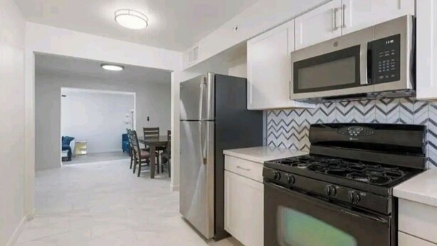 A modern kitchen with stainless steel appliances, a microwave, and a stove. - House in Cozy Old Town Scottsdale with AC, Pool Table, Central Location (Scottsdale)