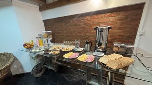 Un bufé de desayuno con diversos alimentos, una cafetera y un tostador.