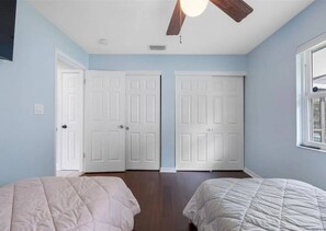 A bedroom with two beds, a ceiling fan, and a window. - 3BR | Saltwater Pool + Spa | Solar Heated | 9 Min to Airport | Sleeps 7 (Clearwater)