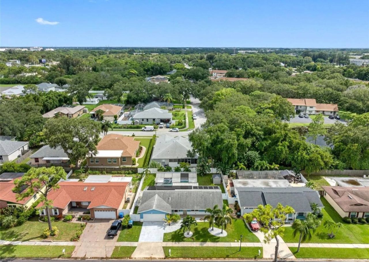 A residential area with houses, green lawns, and trees.