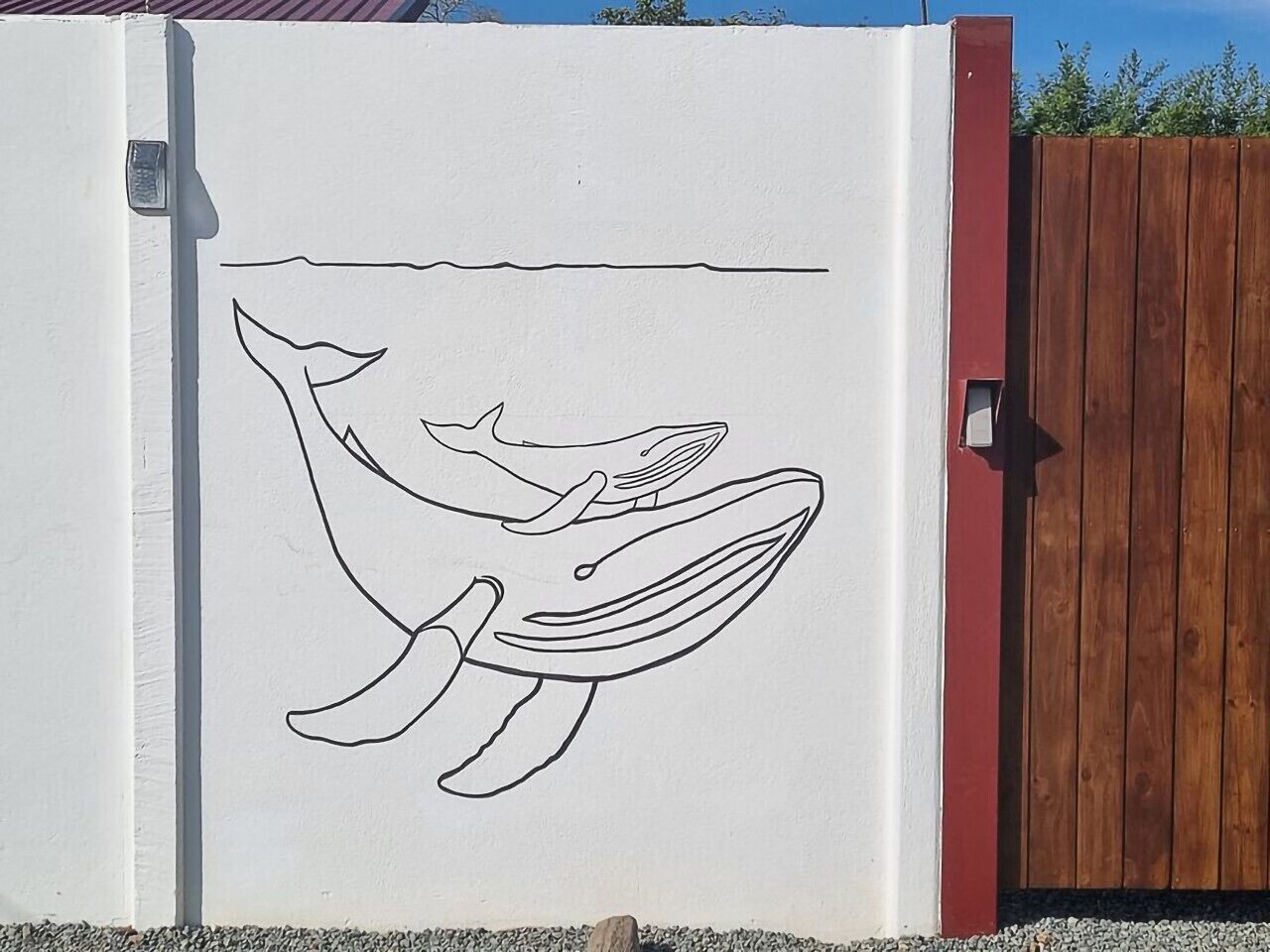 Ein weißer Kühlschrank mit einer schwarzen Walumrisung auf der Tür.