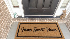 A doormat with the text "Home Sweet Home" on a house's front door. - Perfect Stop • Near I-95, Downtown & Civic Center and Darlington (Florence)