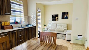 Una cocina moderna con armarios de madera, una mesa de comedor y una mesa de centro de vidrio.