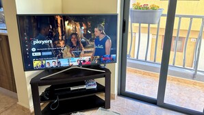 Un televisor de pantalla plana sobre un soporte, con la interfaz de Netflix mostrando un programa titulado 
